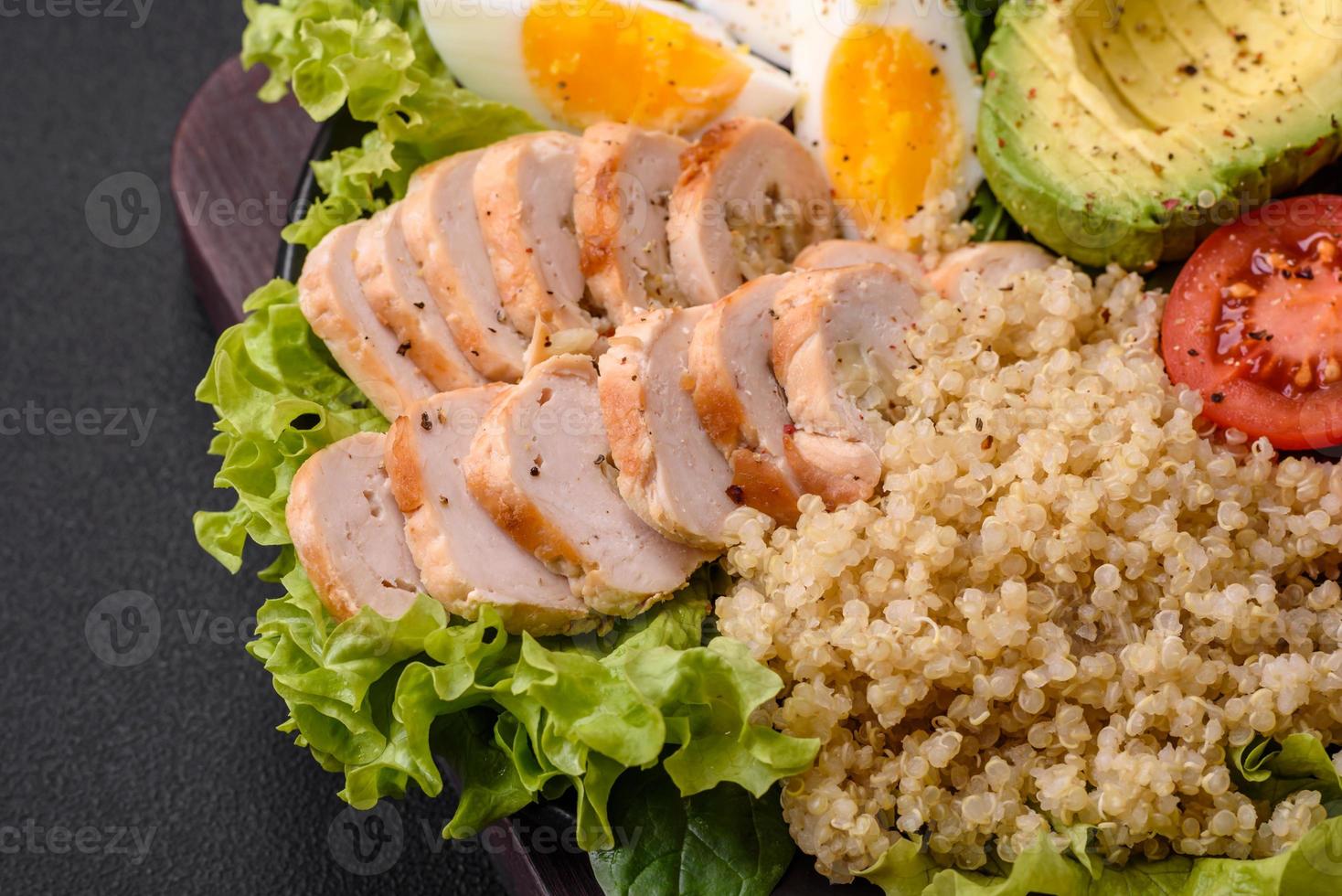 delizioso salutare pranzo consistente di pollo, avocado, quinoa, uova e pomodori foto