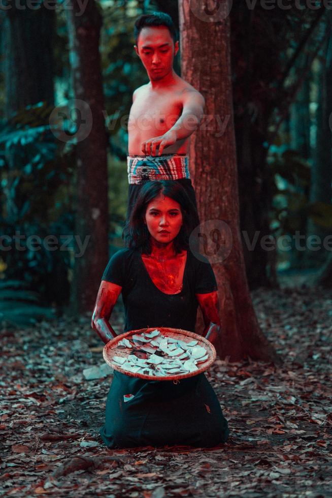 un' coppia di seriale assassini avere corpi coperto nel sangue e siamo l'esecuzione un' satanico rituale nel il mezzo di un' foresta foto