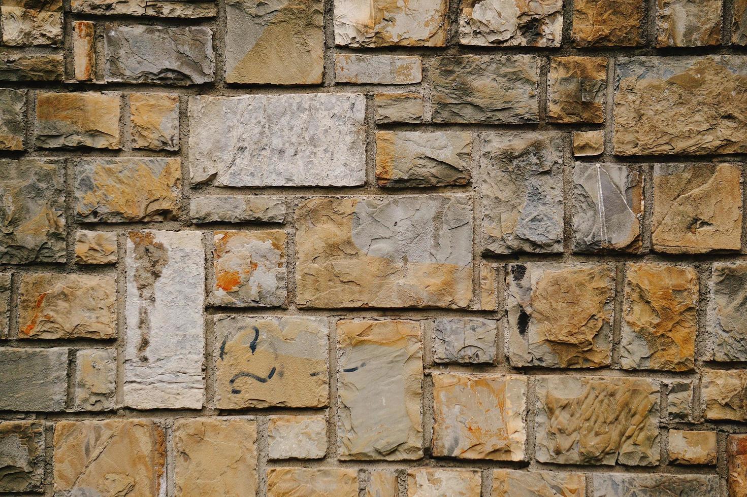 Priorità bassa strutturata del muro di pietra arancione foto