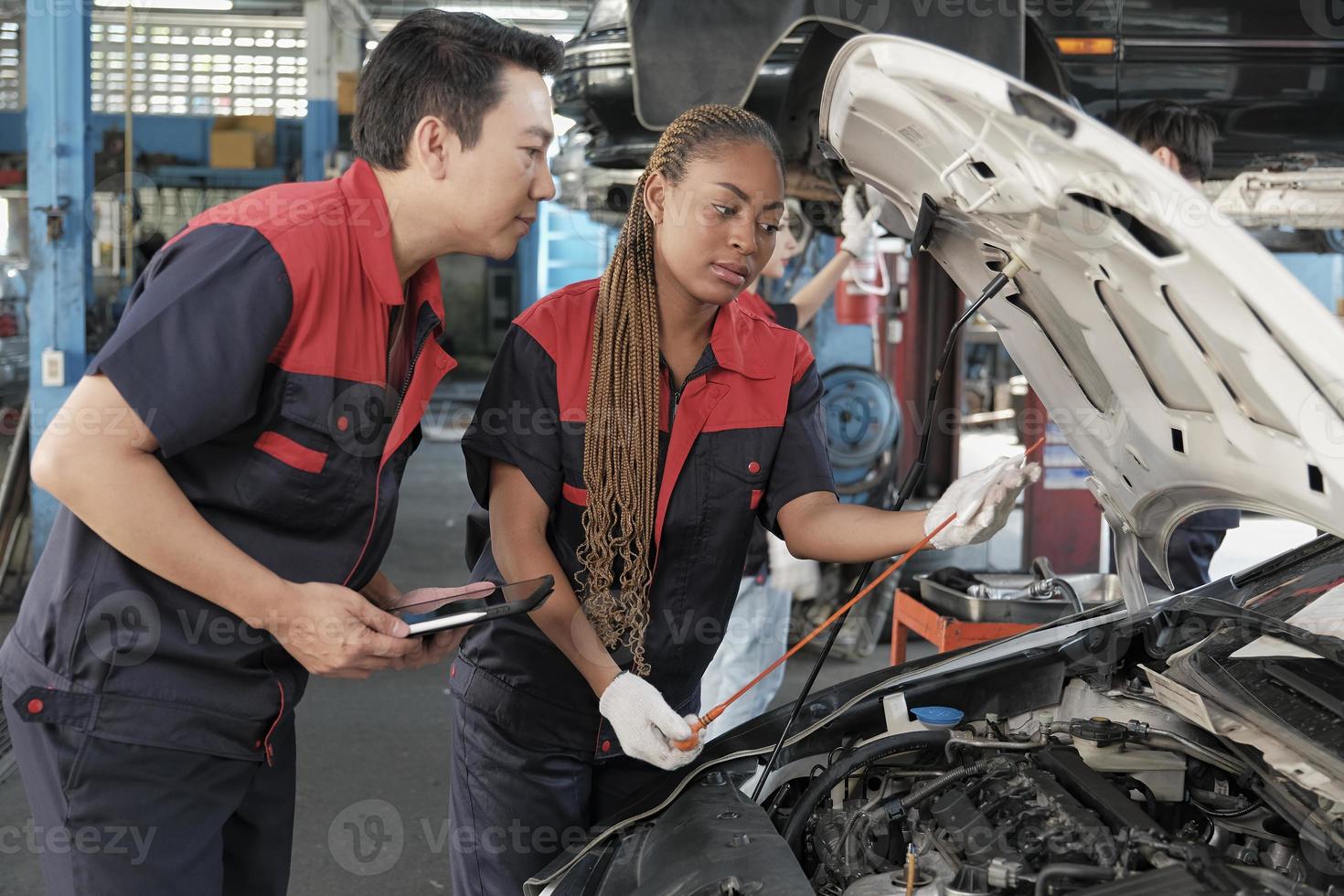 maschio professionale settore automobilistico supervisore consiglia e ispeziona nero femmina meccanico lavoratore di liquido motore olio a auto box auto, servizio Manutenzione, e fissaggio specialista occupazioni auto industria. foto