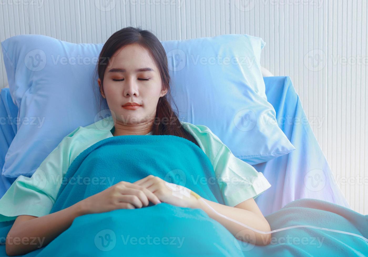 paziente donna asiatica giace in attesa di un medico foto