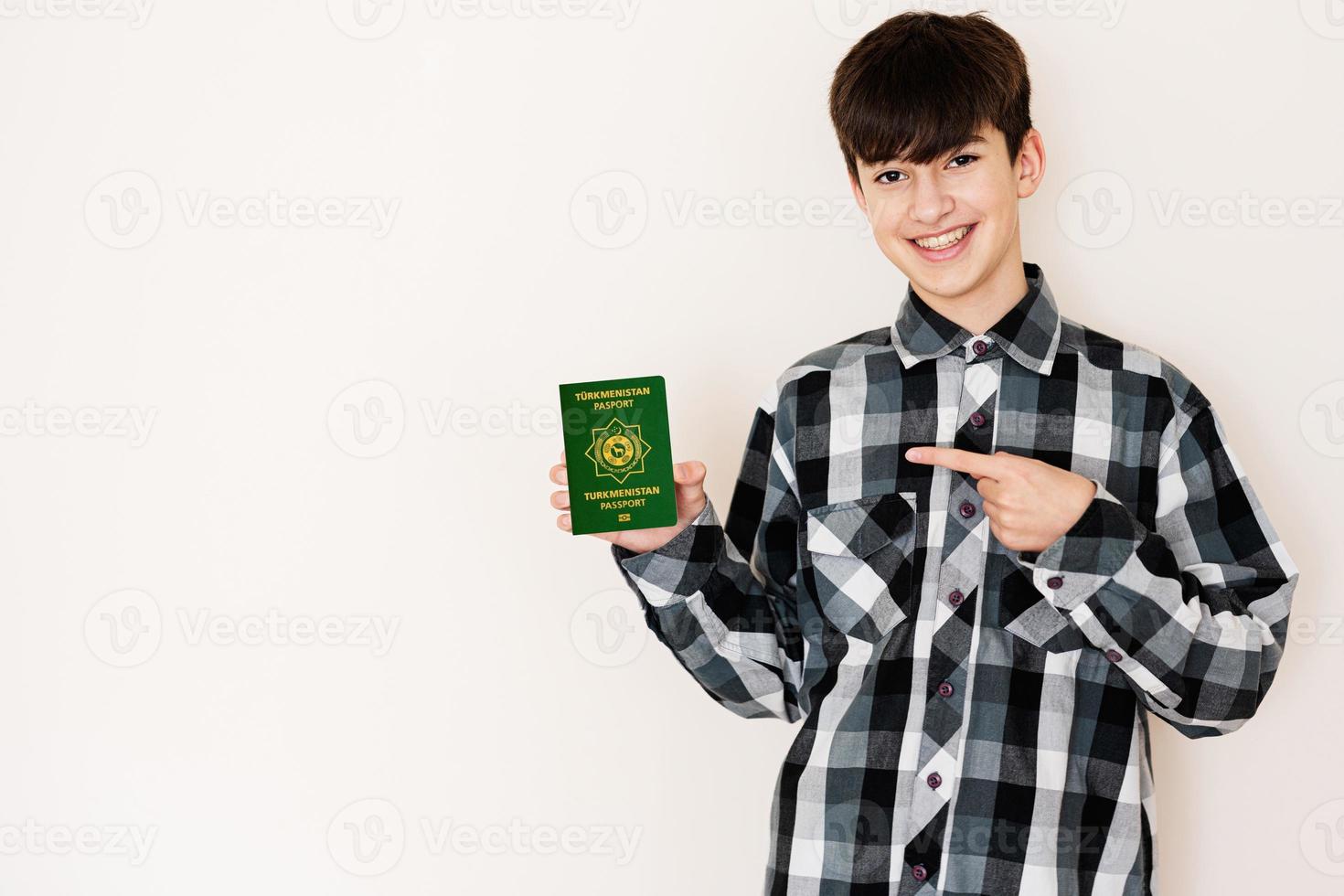 giovane adolescente ragazzo Tenere turkmenistan passaporto guardare positivo e contento in piedi e sorridente con un' fiducioso Sorridi contro bianca sfondo. foto