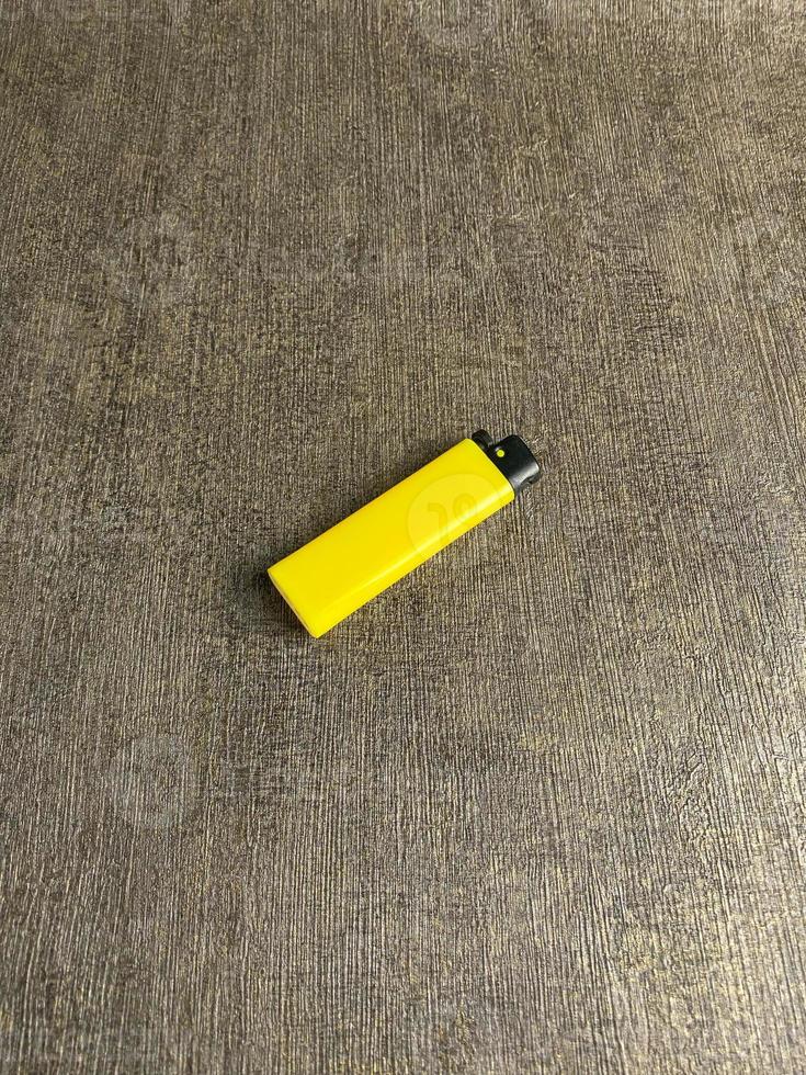 giallo accendino isolato su bianca sfondo. mano provato per illuminato giallo accendino. copia spazio. selezionato messa a fuoco foto