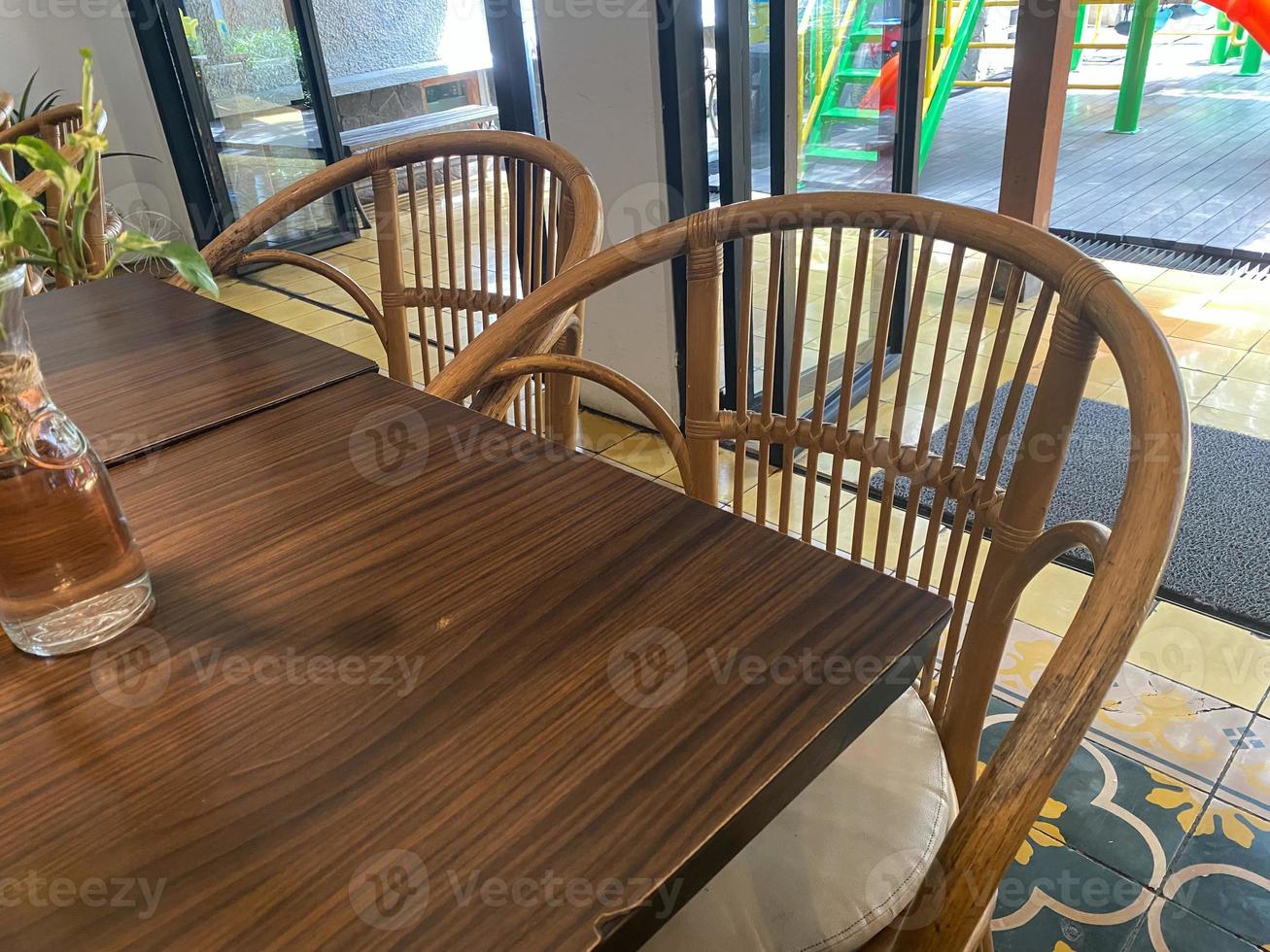 interno di ristorante con di legno tavolo e di legno ornamento. vuoto posto a sedere e tavolo nel ristorante. vicino su pulito tavolo e sedia foto