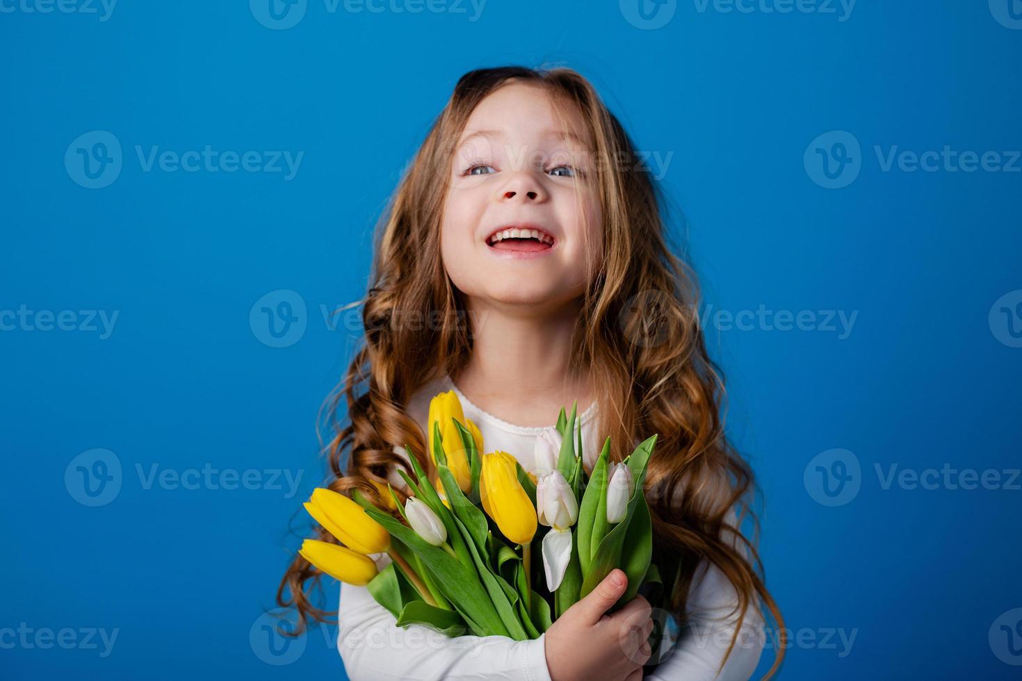 ritratto di un' affascinante sorridente poco ragazza con un' mazzo di tulipani nel sua mani. stile di vita. fresco fiori. internazionale Da donna giorno. spazio per testo. alto qualità foto