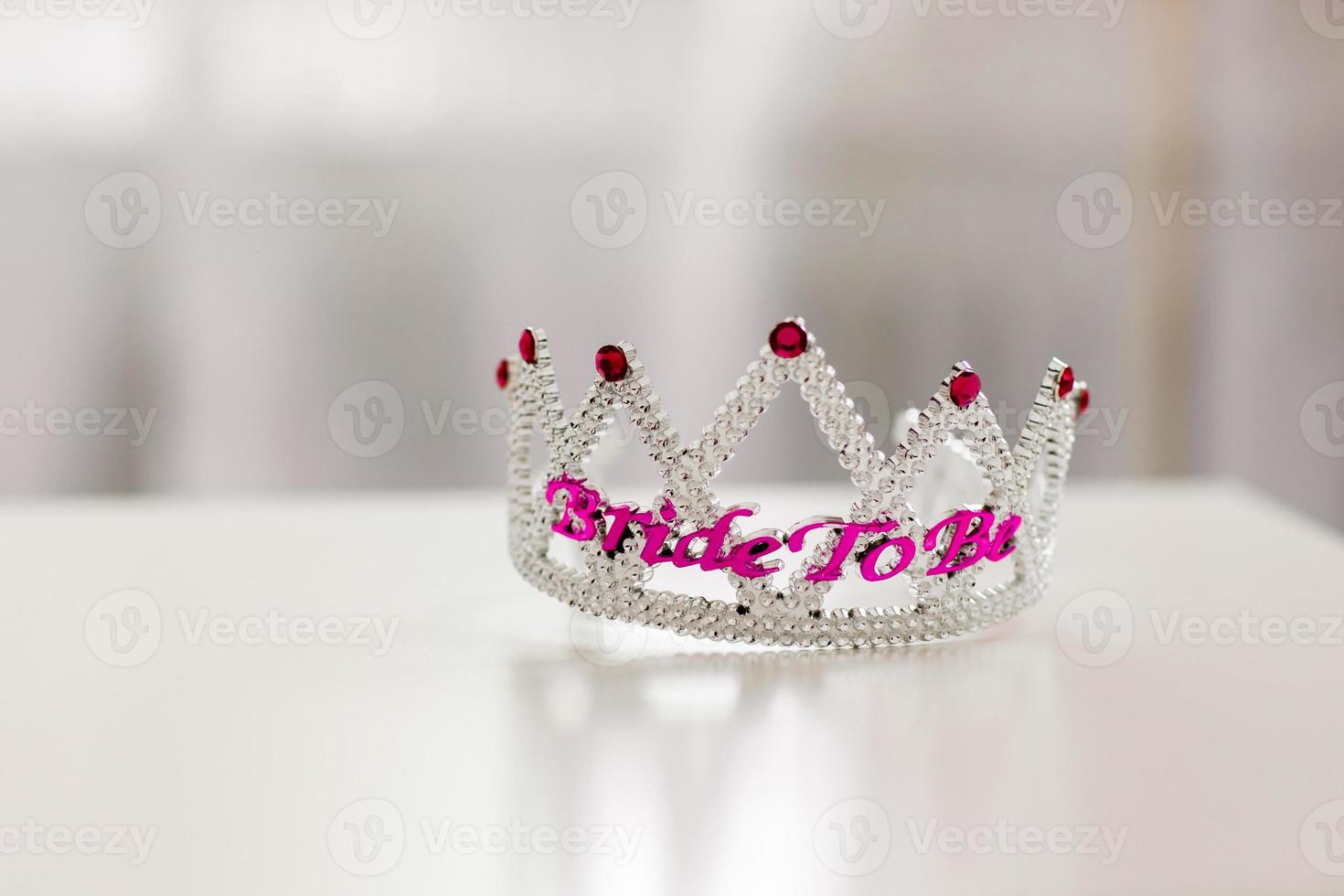 plastica incoronato gioiello corona o tiara con viola perline su un' bianca sfondo con il parola sposa per essere foto