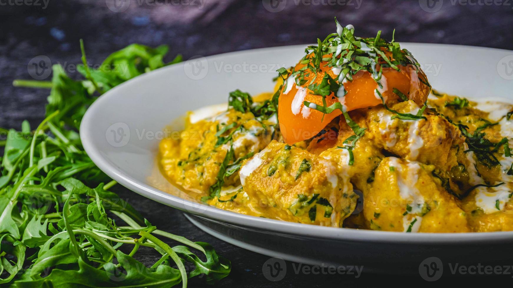 Noce di cocco pollo curry marinata con salsa e coriandolo su un' bianca piatto nero sfondo. foto