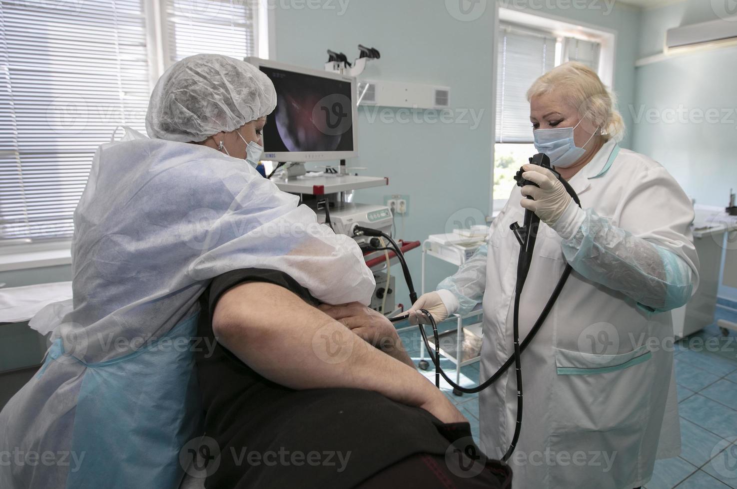 un' femmina medico detiene un endoscopio durante un' gastroscopia per un' ospedale paziente. medico ufficio per diagnosi addominale dolore. foto