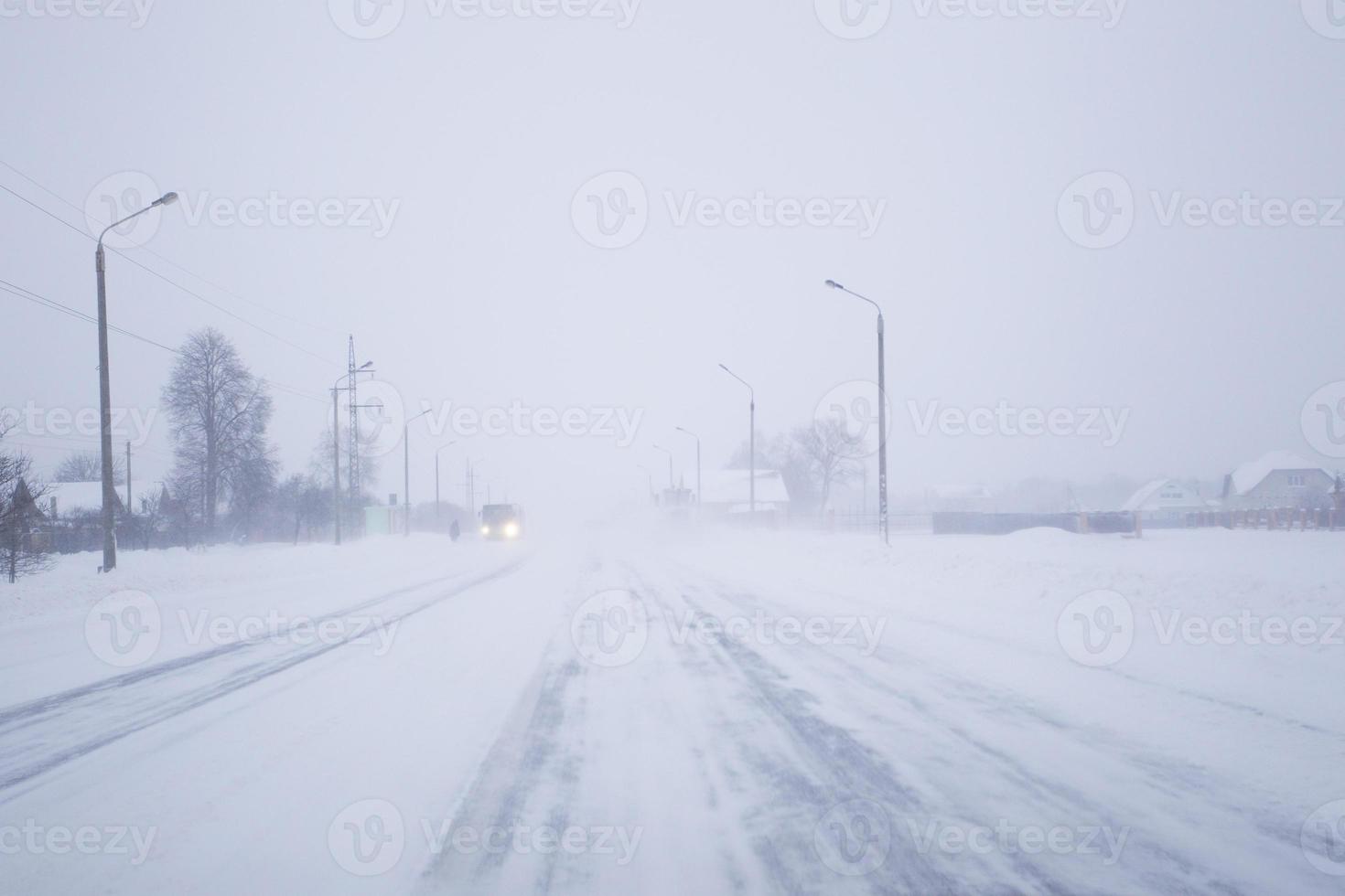 neve coperto nebbioso strada nel cattivo inverno tempo atmosferico. foto