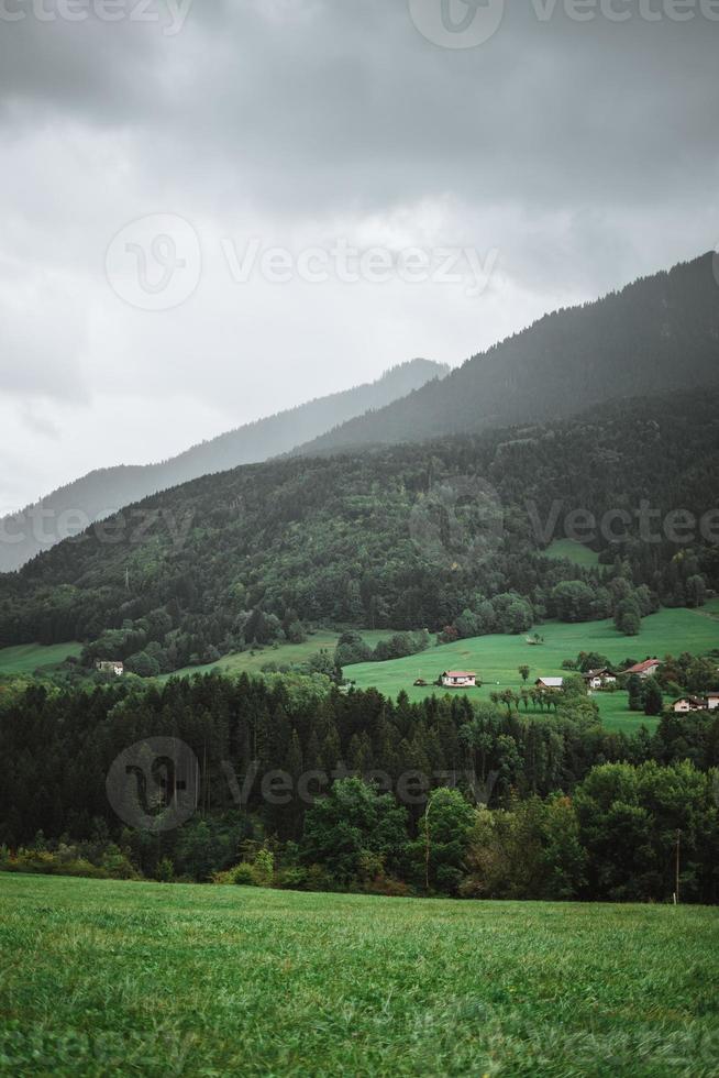 maestoso montagne nel il Alpi coperto con alberi e nuvole foto