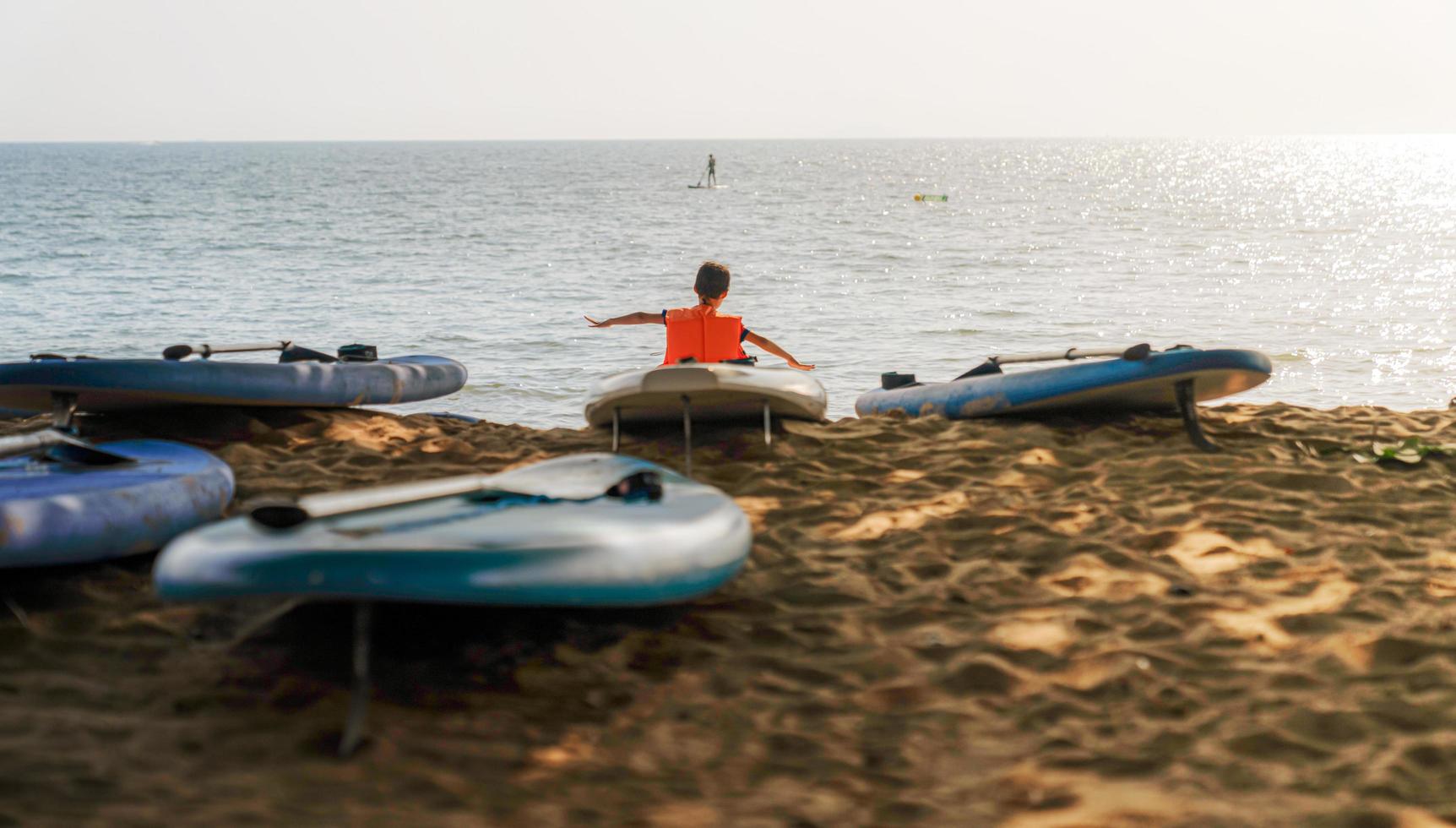 chon buri, Tailandia, 14 novembre 2022.poco ragazzo giocando su il spiaggia a il tramonto volta. persone avendo divertimento all'aperto. concetto di contento e ispirazione, chon buri Provincia, Tailandia. foto