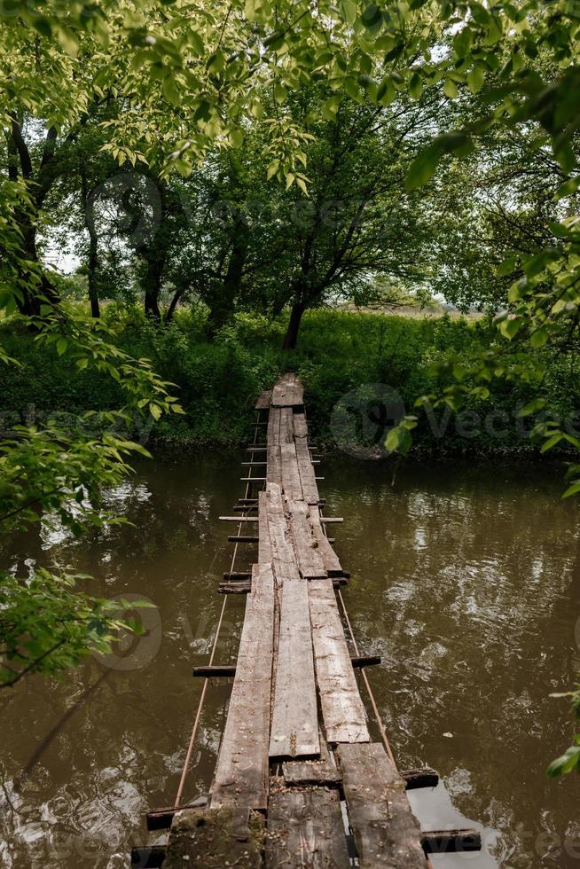 vecchio ponte di legno, ponte di legno su un piccolo fiume, ponte con la natura. foto