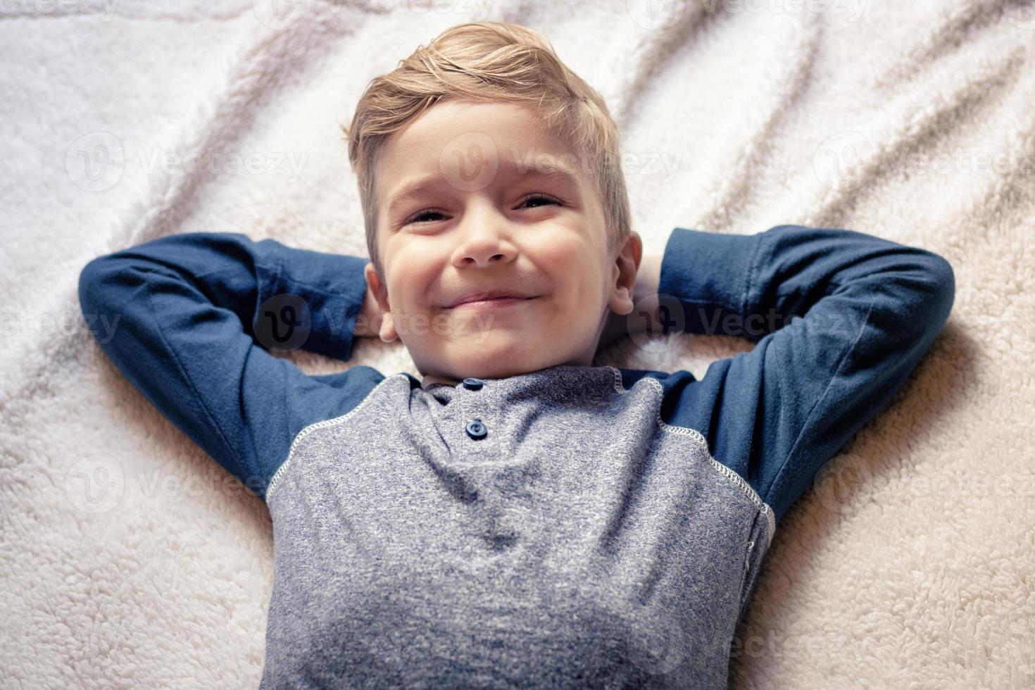 contento ragazzo rilassante su il letto. foto