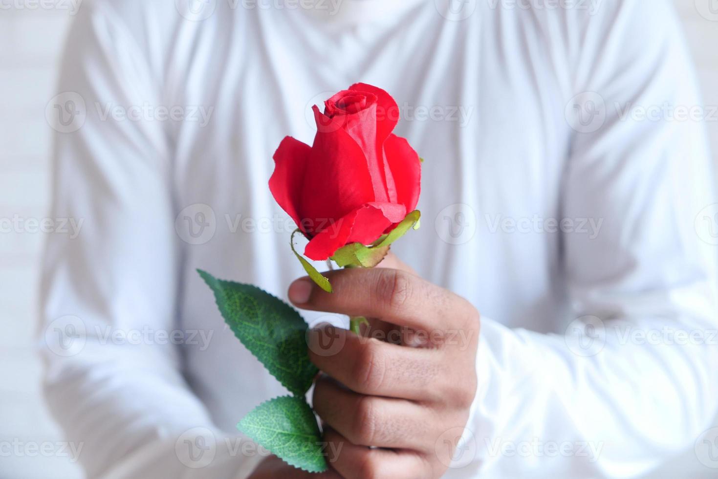 uomo che tiene una rosa rossa foto