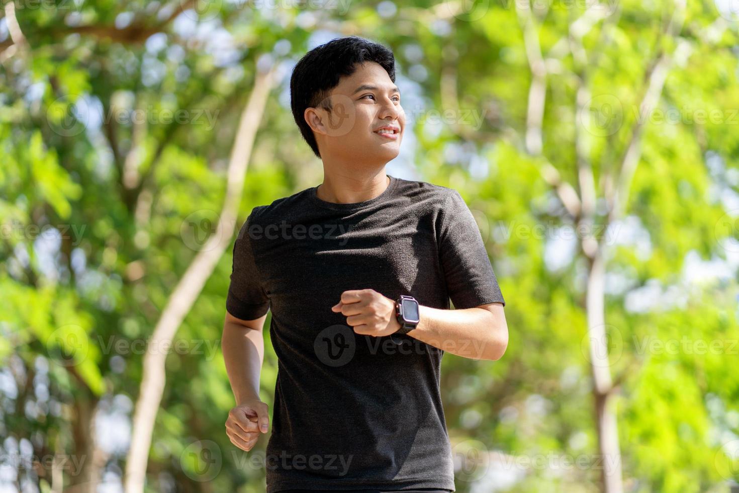 asiatico uomo jogging a il parco nel il mattina foto