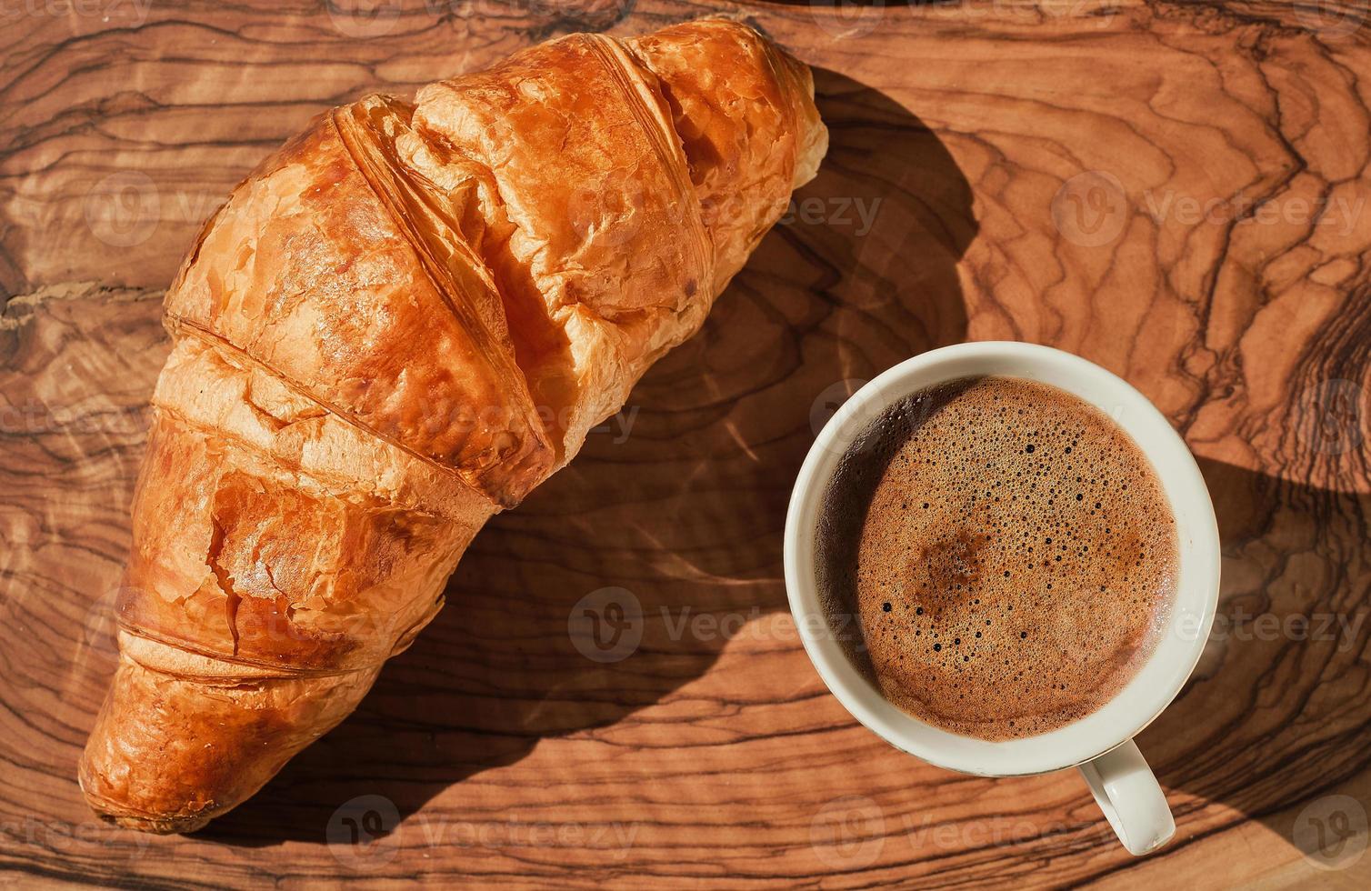 caffè e brioche su di legno tavolo, francese prima colazione idea, soleggiato luminosa giorno. superiore Visualizza piatto posare con copia spazio per testo foto
