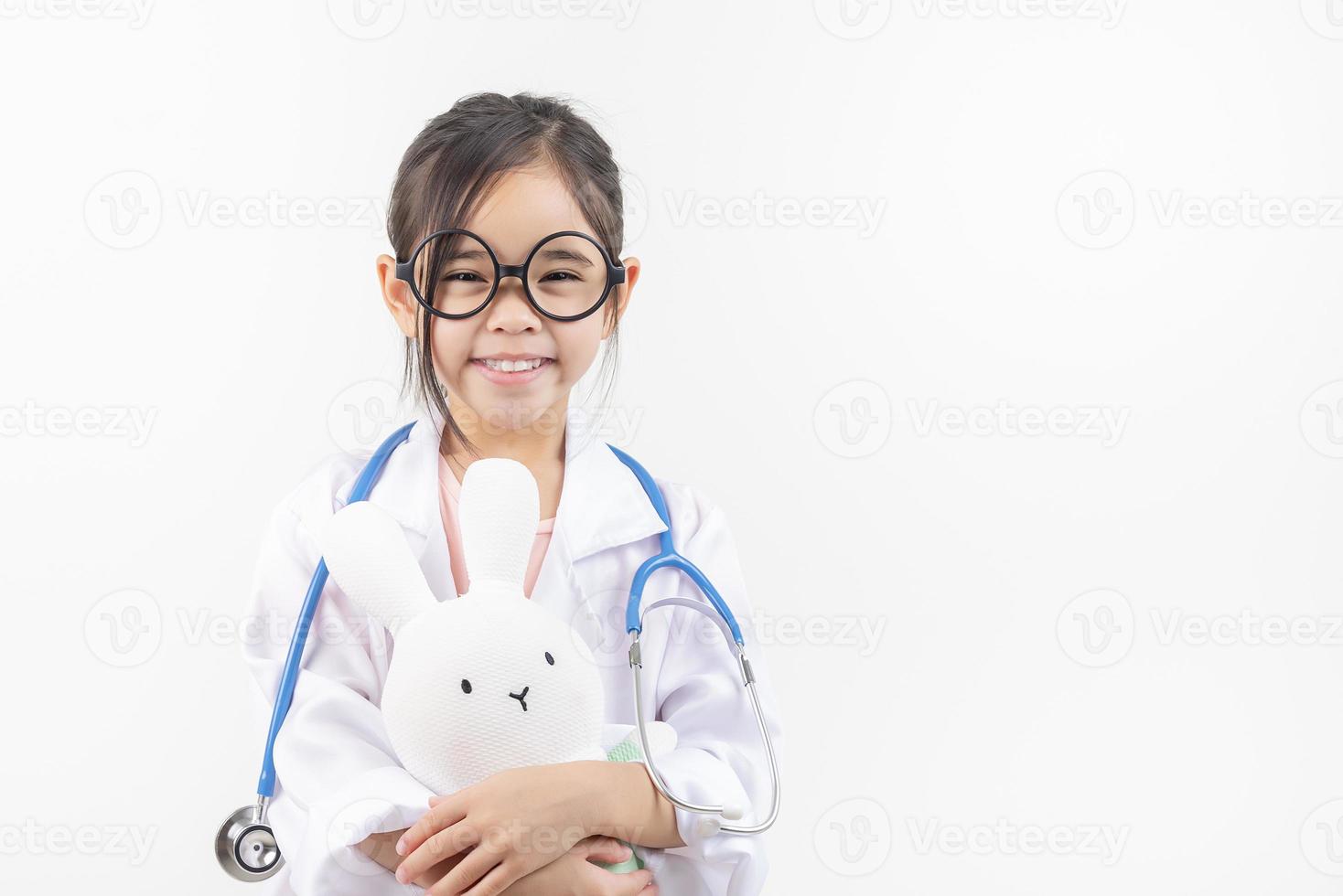 Asia poco ragazza giocando medico isolato su bianca foto