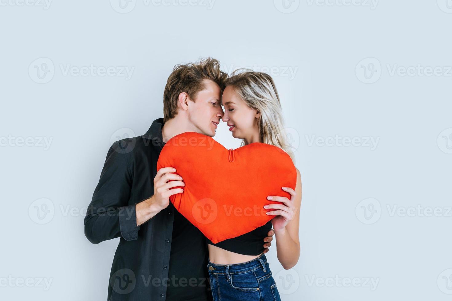 coppia felice amorevole insieme in possesso di un cuore rosso foto
