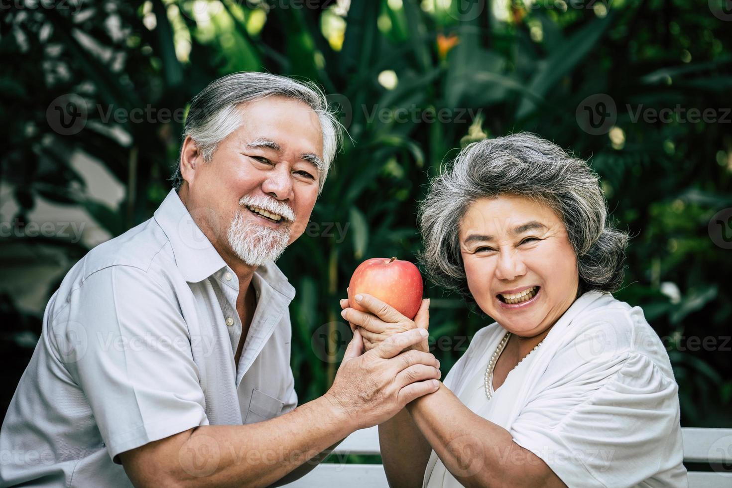 coppia di anziani giocando e mangiando un po 'di frutta foto