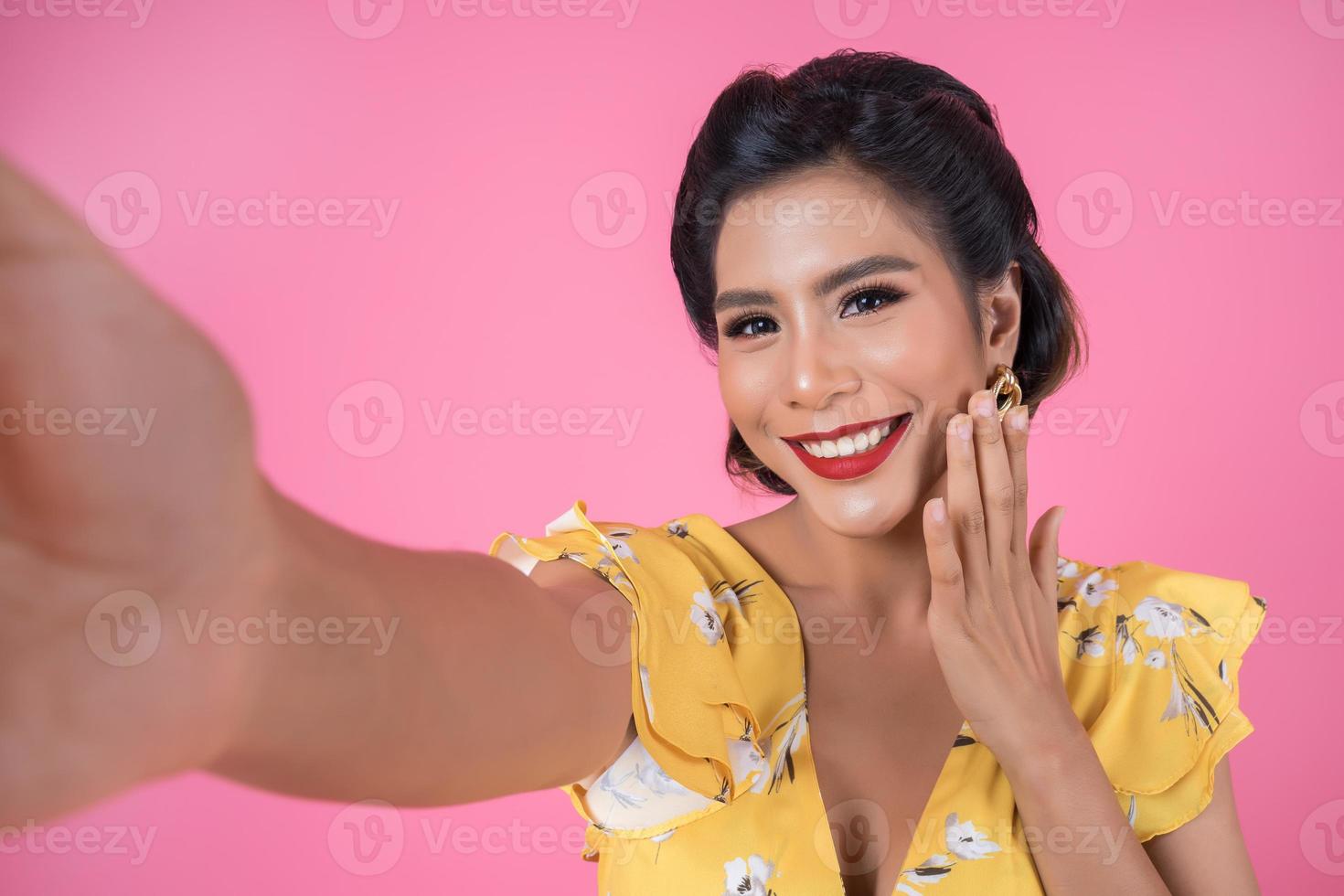 bella donna alla moda prendendo un selfie con il suo telefono foto