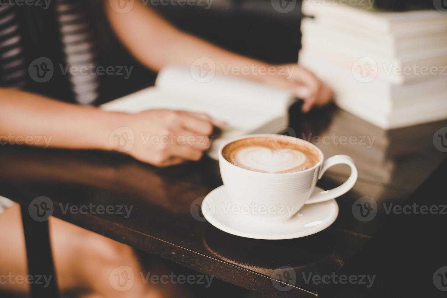 donna asiatica che si rilassa e che legge un libro nella caffetteria foto