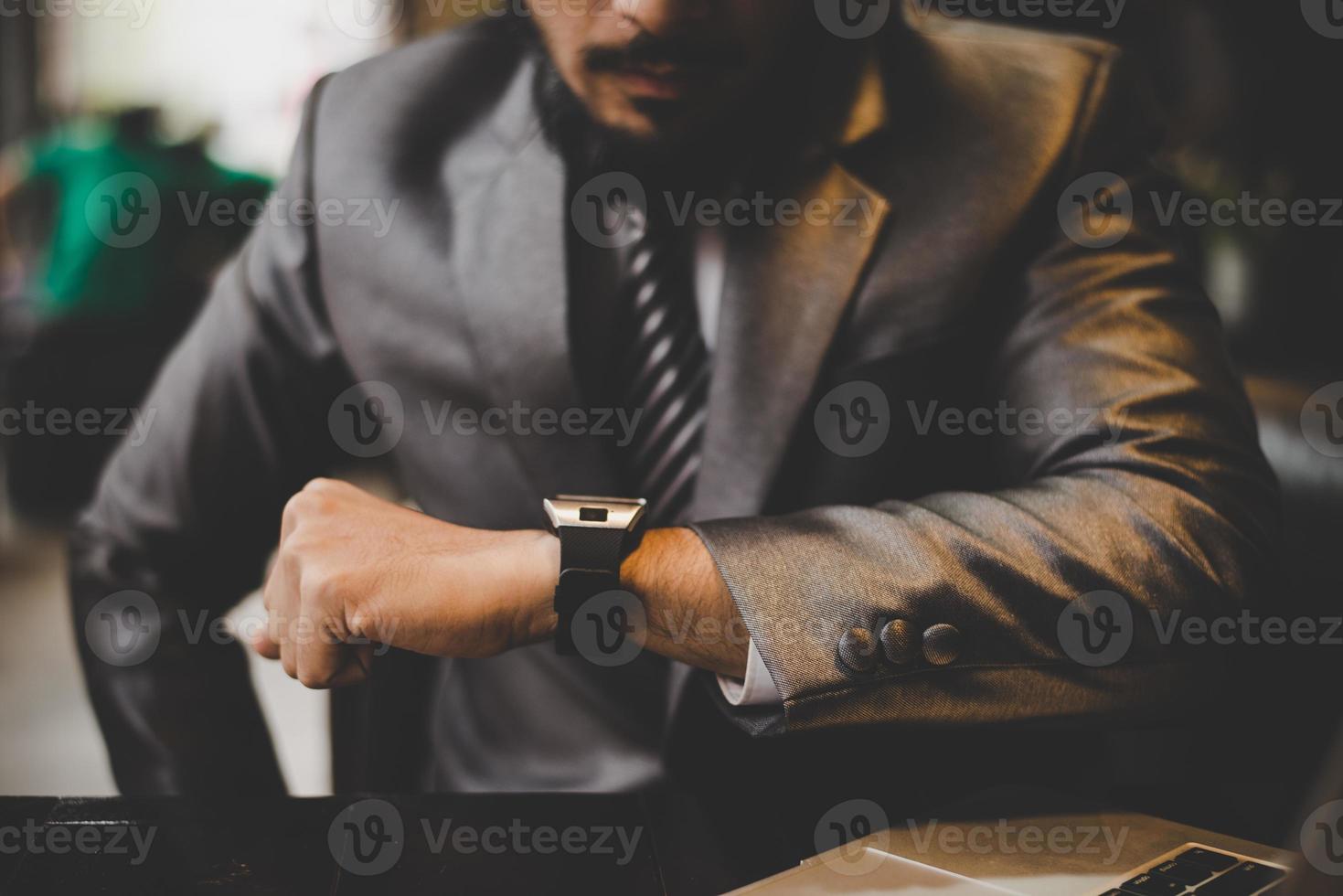 primo piano della mano dell'uomo d'affari che guarda l'orologio della mano foto