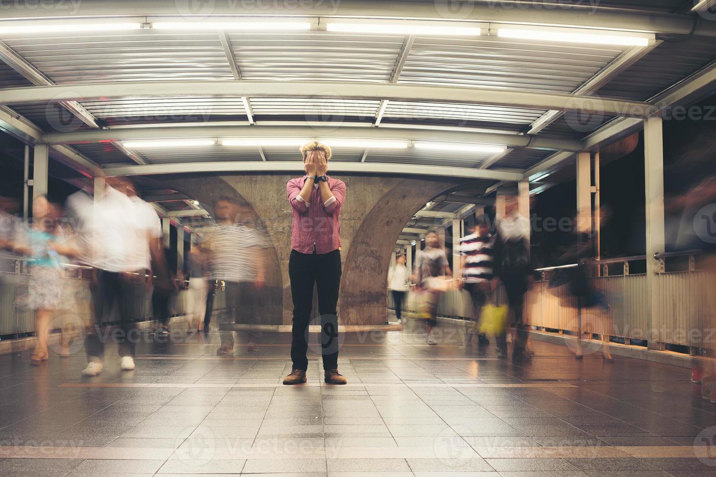 uomo barbuto hipster in piedi sul pavimento con sfondo di movimento di persone foto