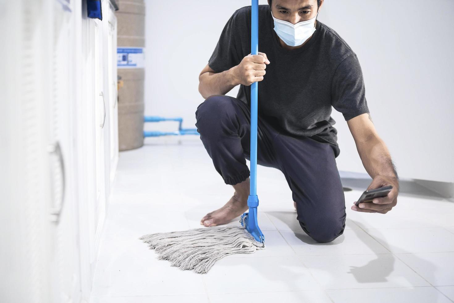uomo asiatico che pulisce il pavimento foto