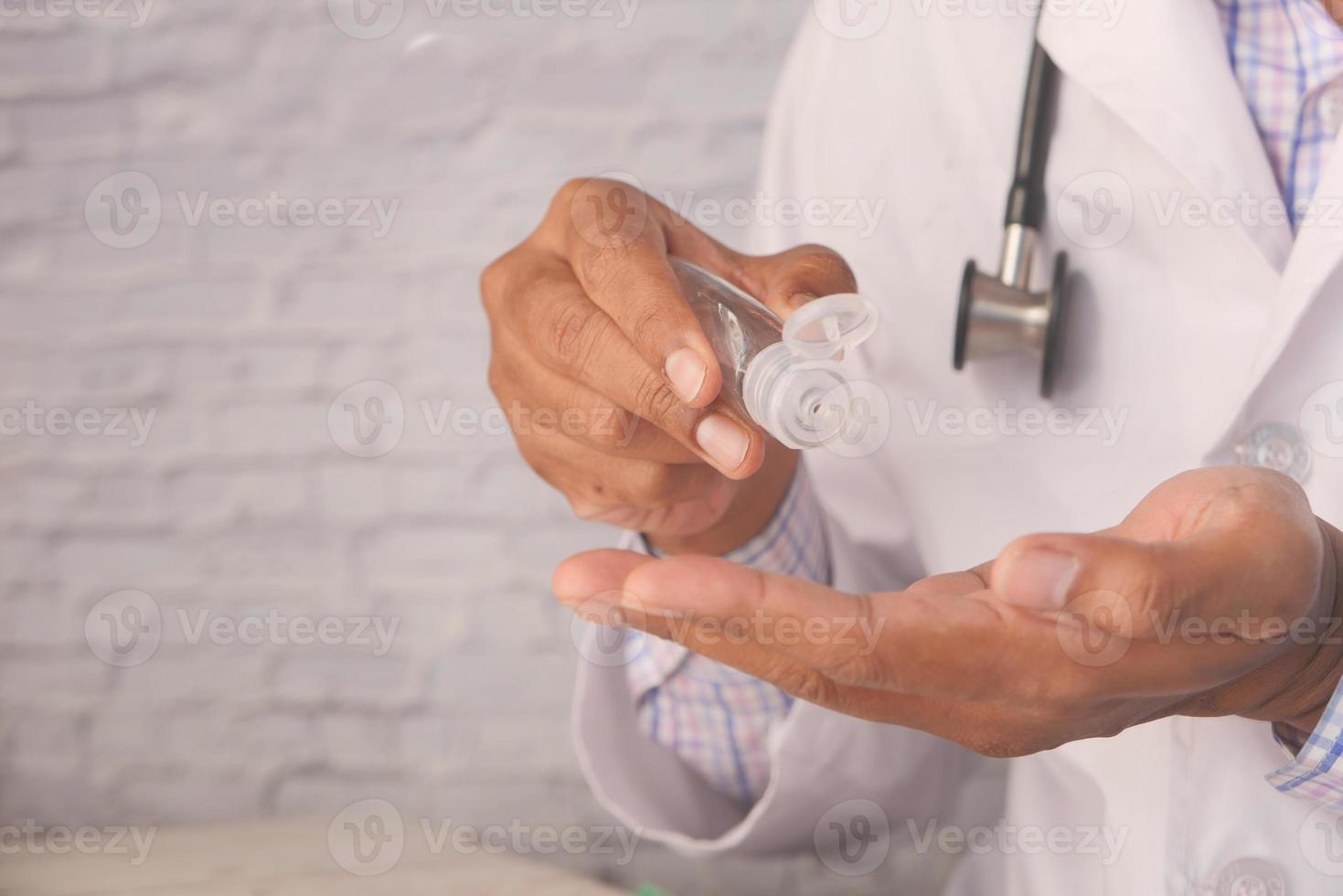 mano del medico utilizzando gel igienizzante foto