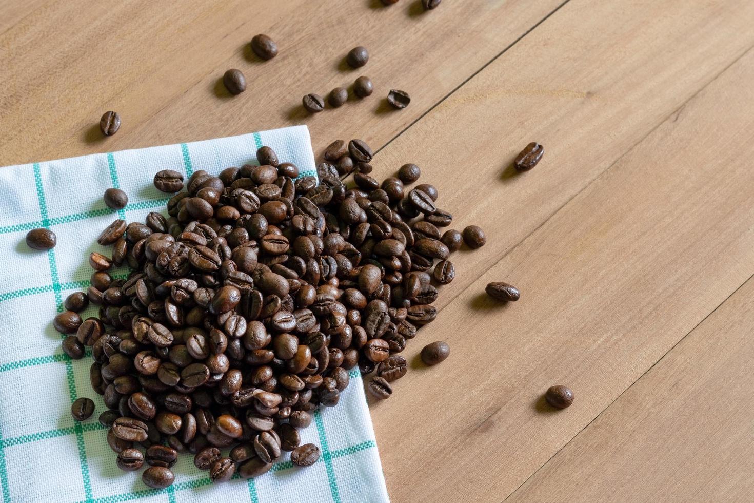 chicchi di caffè tostati su fondo in legno foto