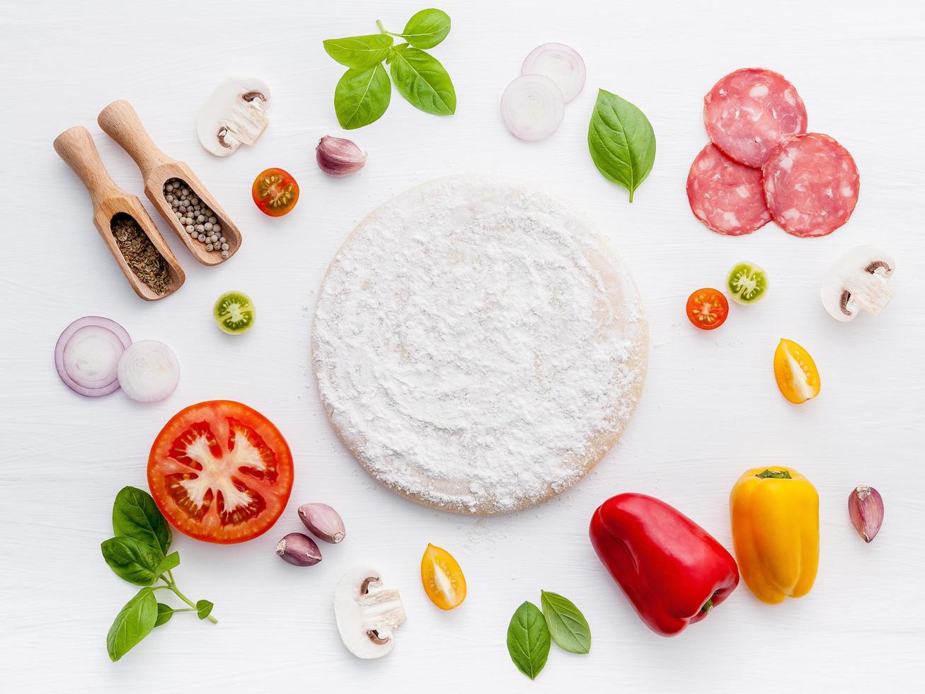 impasto della pizza circondato da ingredienti freschi foto