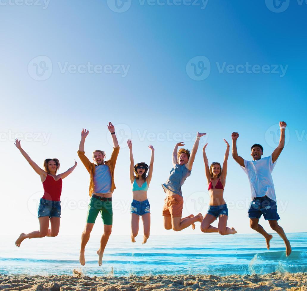 contento sorridente amici salto a il spiaggia foto