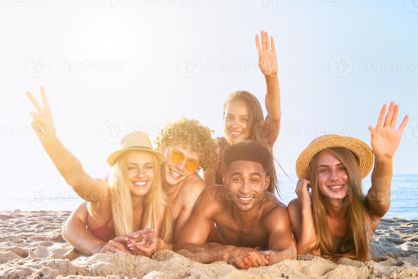 gruppo di amici avendo divertimento su il spiaggia foto