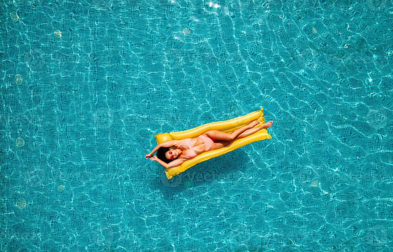 ragazza nel costume da bagno chi abbronzatura nel un' nuoto piscina foto