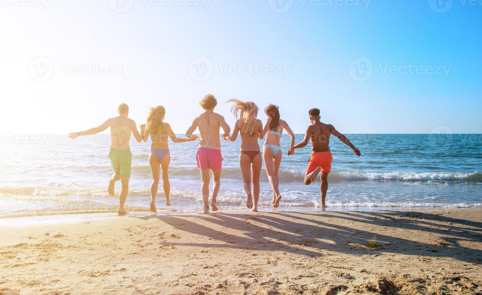 gruppo di amici correre nel il mare. concetto di estate foto