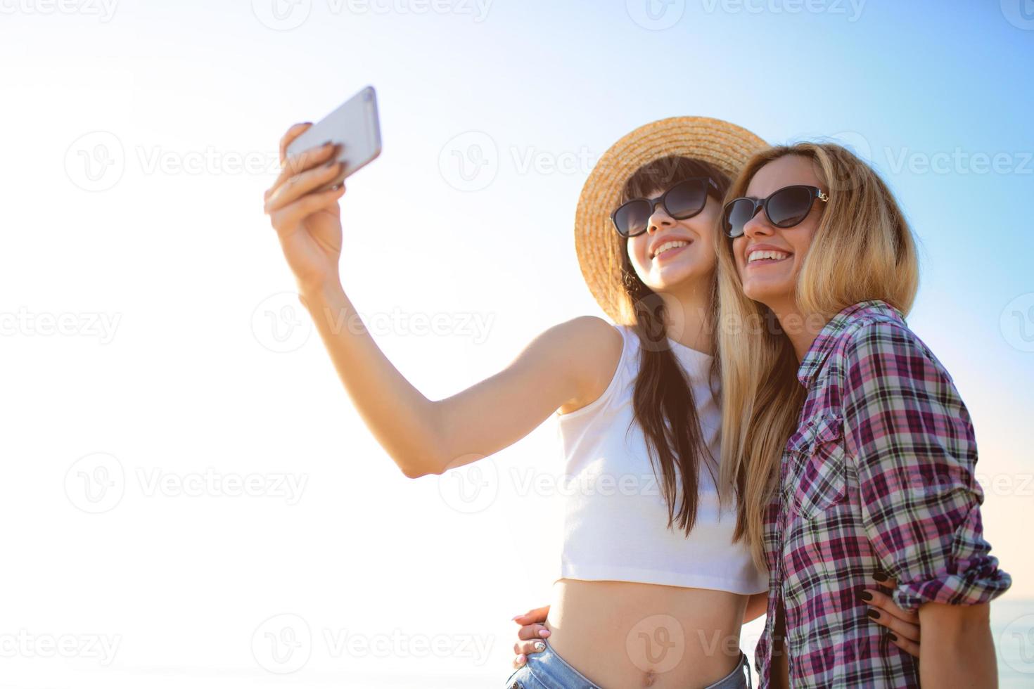 contento gruppo di amico fa un' autoscatto con un' mobile Telefono. foto