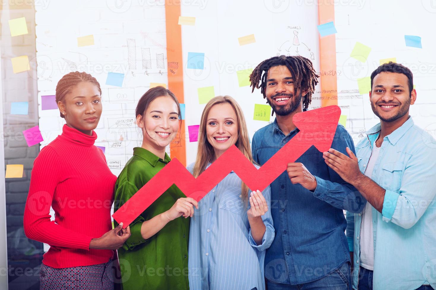 giovane contento e colorato attività commerciale squadra hold un' rosso statistico freccia. concetto di in crescita, successo e profitto foto