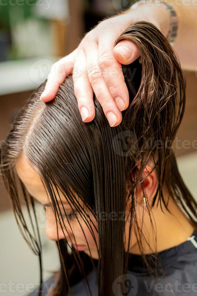 giovane donna ricevente trattamento sua capelli foto