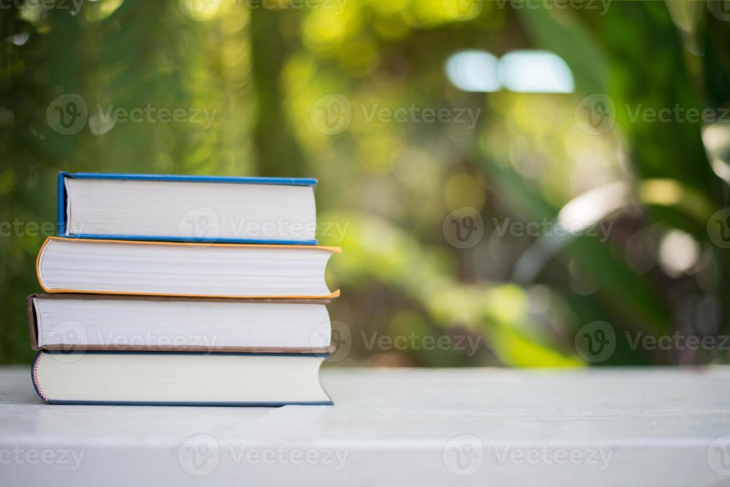 Close up pila di libri, girato all'aperto sotto un chiaro sfondo bokeh di fondo naturale foto