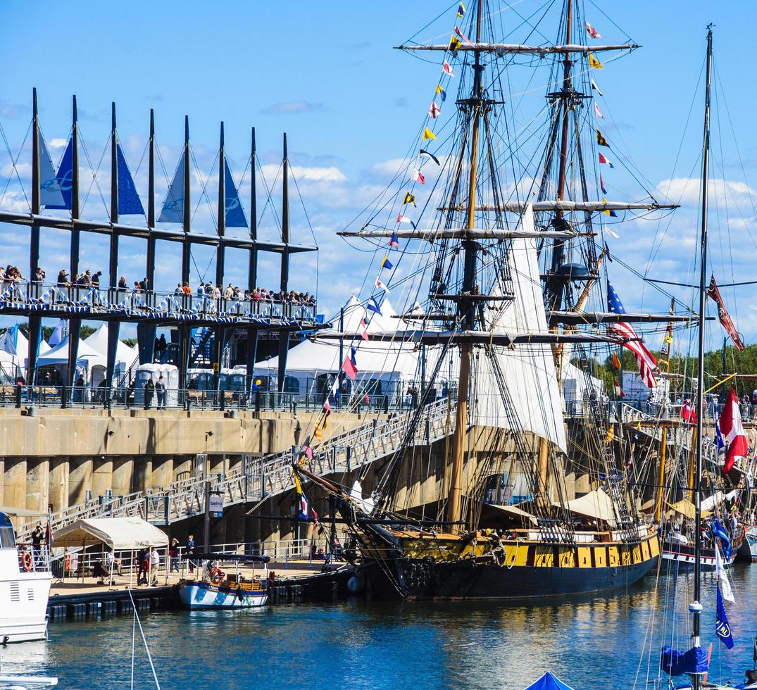 un'antica barca a vela e gruppi di persone al vecchio porto di montreal, quebec, canada foto