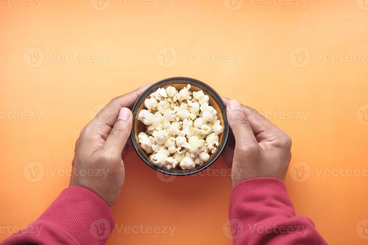 ciotola di popcorn su sfondo arancione foto