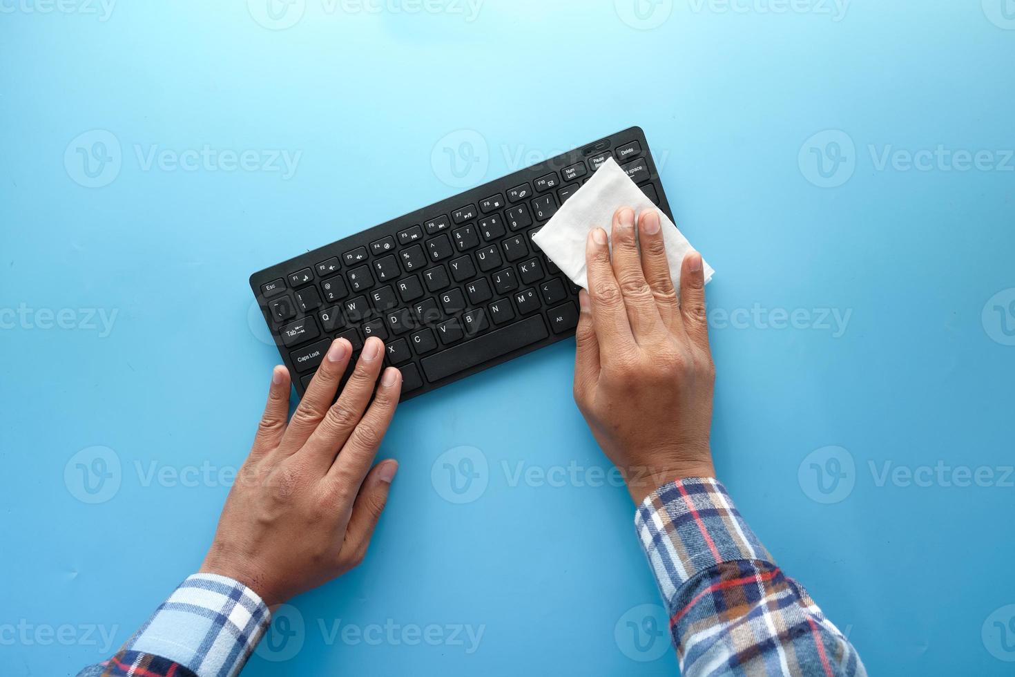 mani che puliscono una tastiera foto