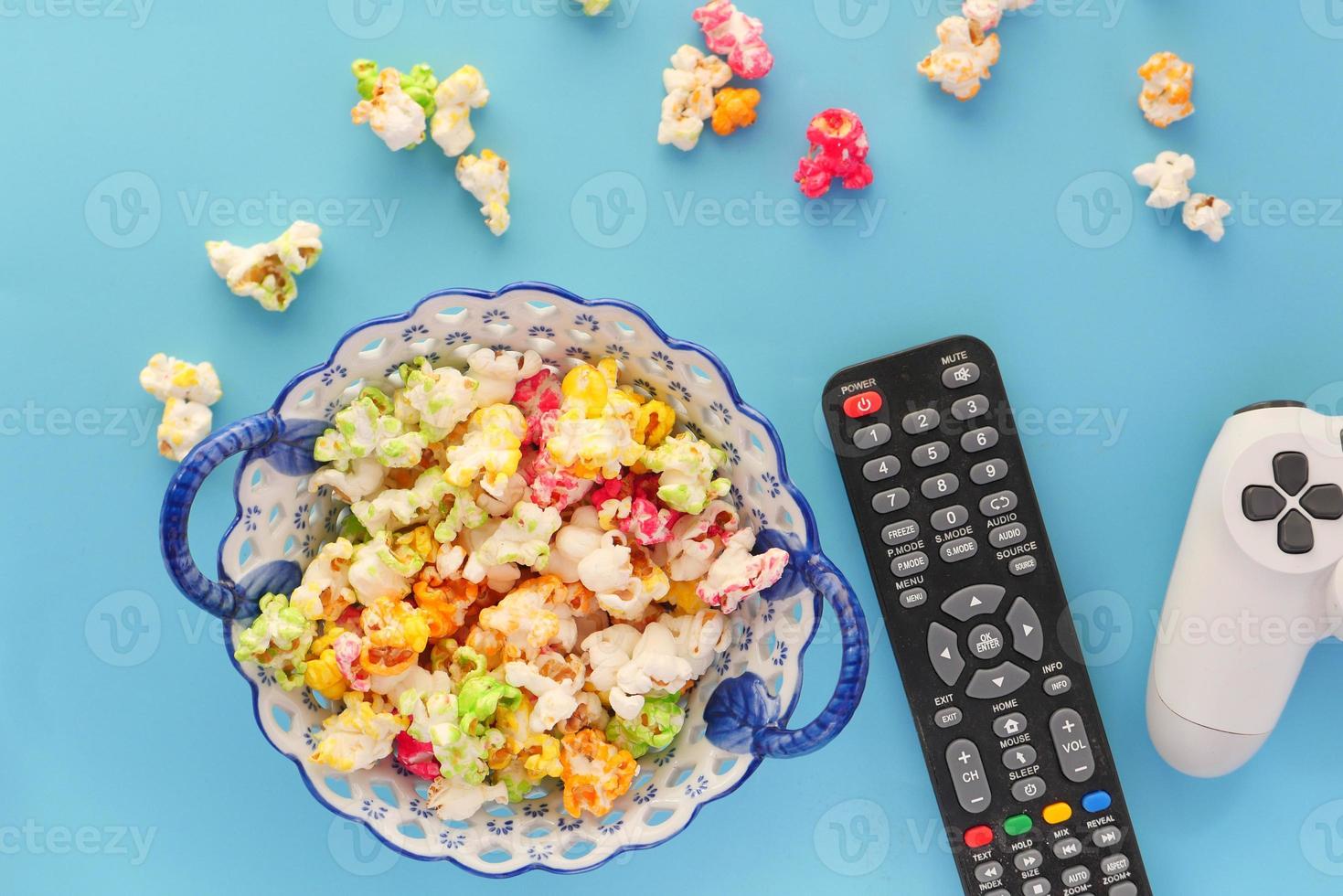 popcorn colorati con telecomando e controller su sfondo blu foto