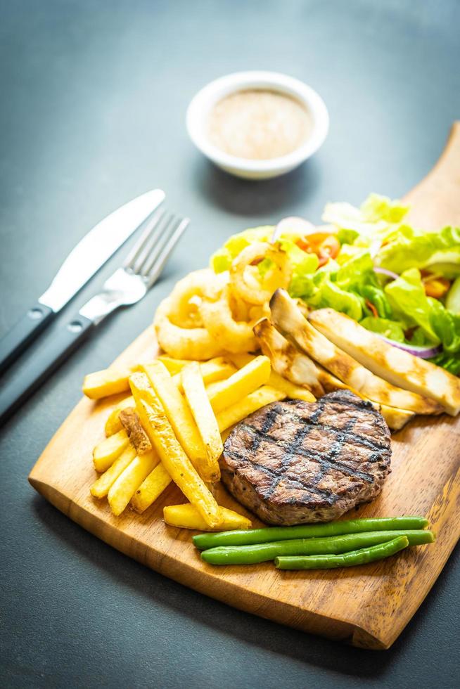 bistecca di manzo alla griglia con patatine fritte, salsa e verdure fresche foto