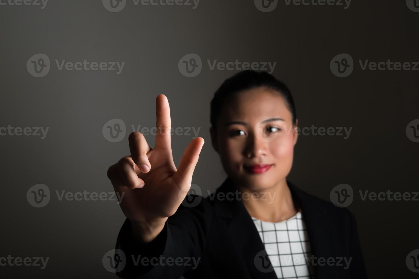 donna d'affari davanti al touch screen visivo isolato su sfondo nero foto