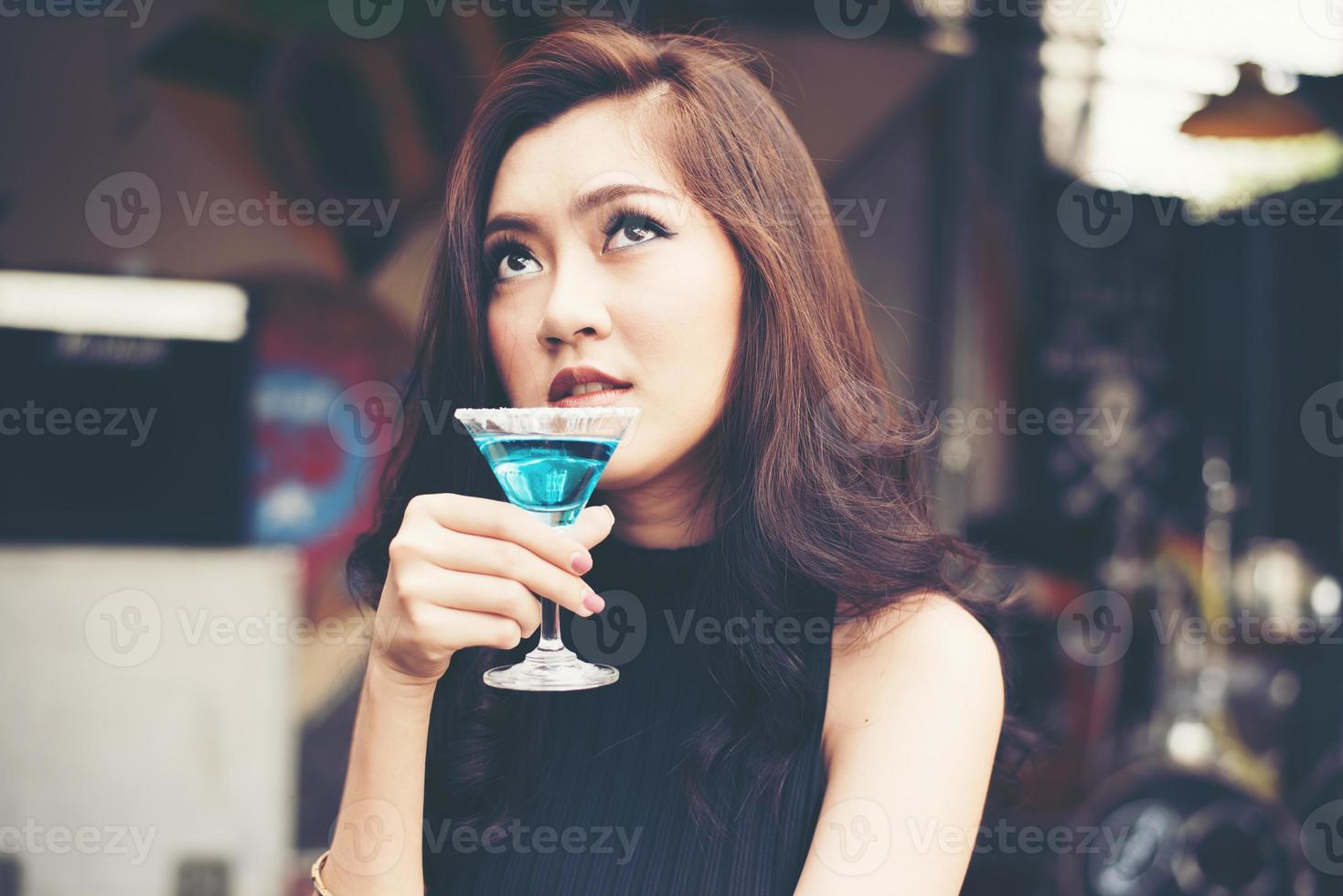 ritratto di una giovane donna felice divertirsi e bere un cocktail foto