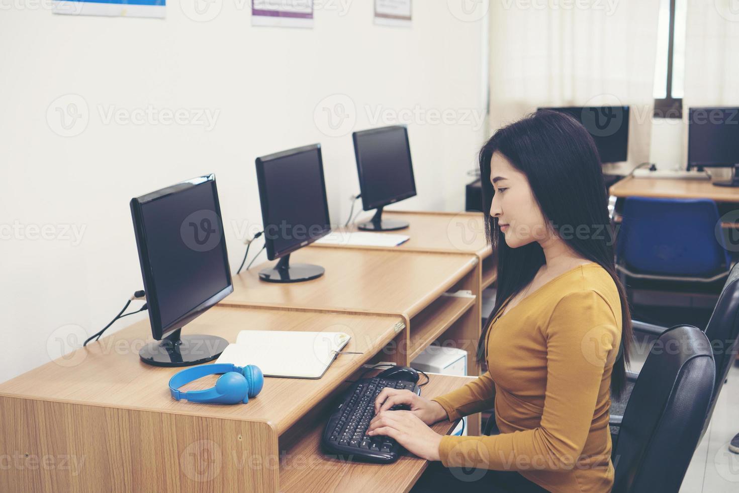 giovane donna che utilizza computer in ufficio foto