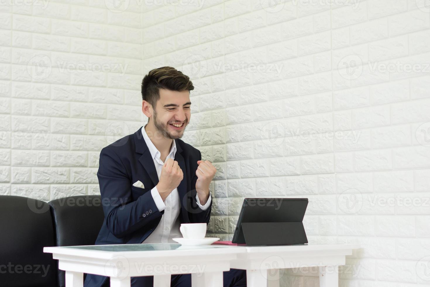 giovane imprenditore di successo che lavora al computer portatile in ufficio foto