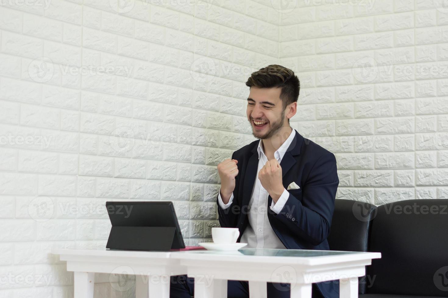 giovane imprenditore di successo che lavora al computer portatile in ufficio foto