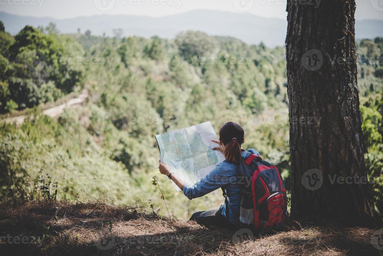 escursionista giovane donna leggendo una mappa durante le escursioni foto